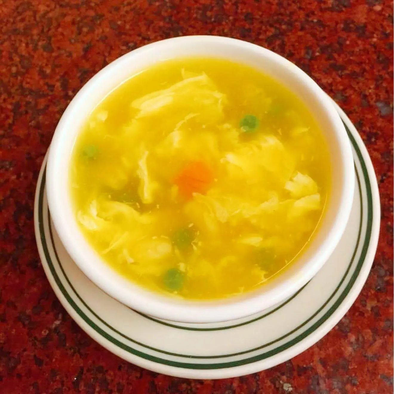 Egg drop soup with peas and carrots in a white bowl at Ocean Sky, a Chinese Restaurant in Chehalis